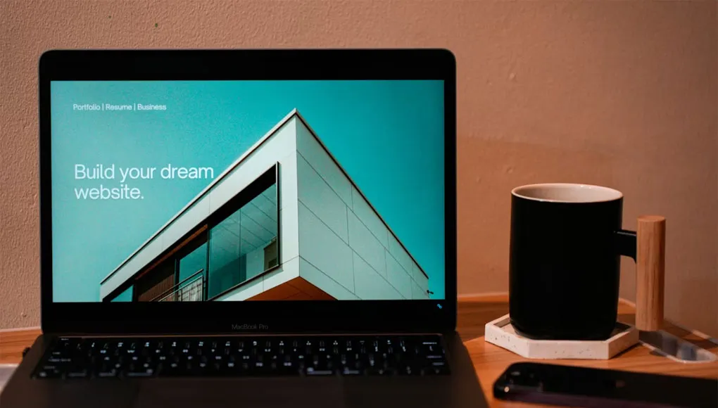 laptop-macbook-pro-aperto-con-sito-di-portfolio-web-design-e-tazza-nera-di-caffe-accanto